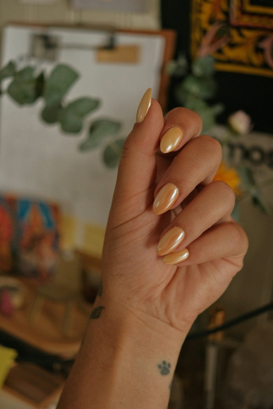 Hand with almond shaped golden chrome nails